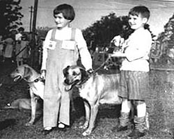 two people with dogs posing