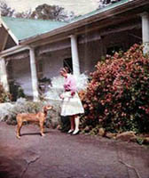 Laurie with dog in front of house