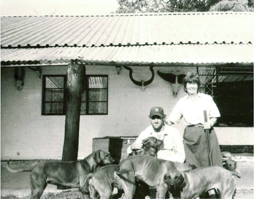 two people at the house with several dogs